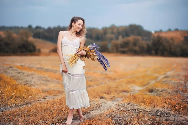 Meisje met een boeket van bloemen in de herfst — Stockfoto