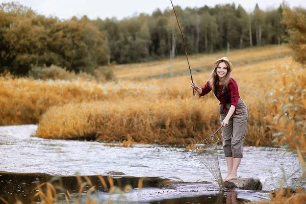 Ragazza in autunno con una canna da pesca — Foto Stock