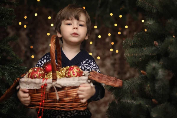 A little child by the New Year tree. Children decorate the Chris — Stock Photo, Image