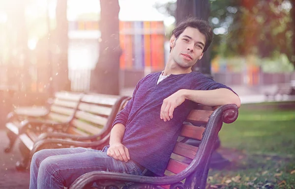 A young man walks in the park at lunch time. A man is on a walk