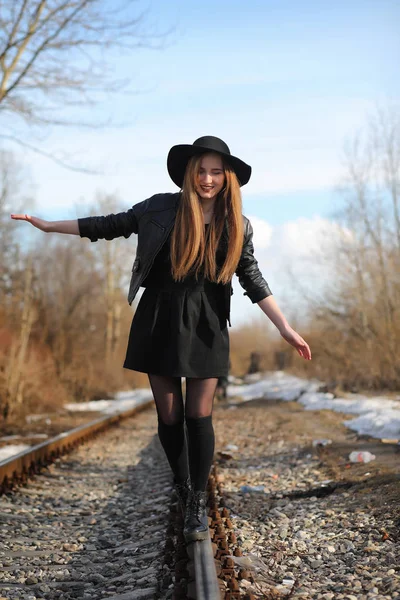 Une fille marche dans la rue de la ville dans un gilet en cuir avec un — Photo