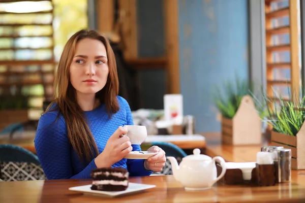 Ung flicka i café sitter och dricker te — Stockfoto