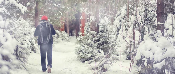 Un hombre viaja con una mochila. Caminata de invierno en el bosque. Touris —  Fotos de Stock