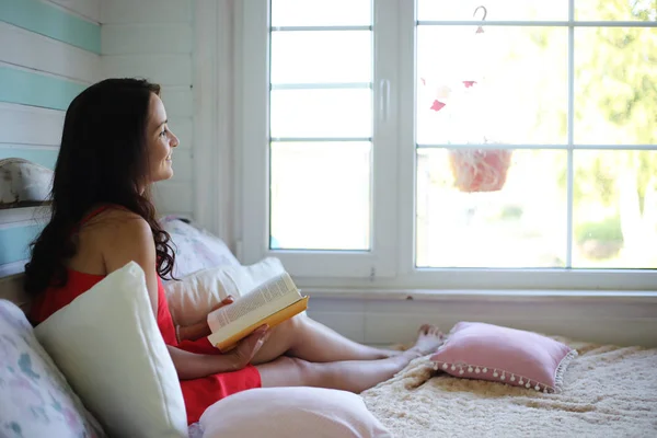 Девушка читает книгу Молодая девушка с дочерью сидят о — стоковое фото