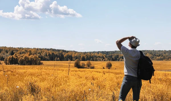 A young man is traveling in nature. Traveling with a backpack on — Stock Photo, Image