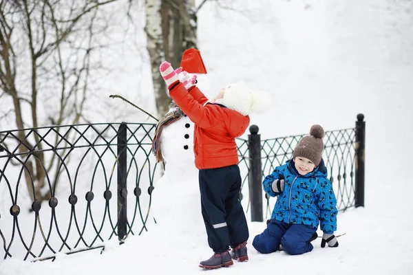 Kışın parktaki çocuklar. Çocuklar oyun oynarken karla oynuyor. — Stok fotoğraf