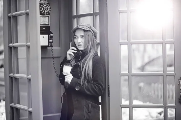 Smuk ung pige i en telefonboks. Pigen taler på th - Stock-foto