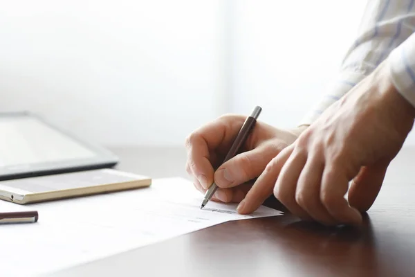 Reunião de negócios. Um homem assina um contrato. Mão masculina com caneta mak — Fotografia de Stock