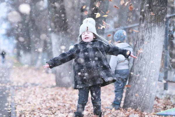 Les enfants marchent dans le parc première neige — Photo