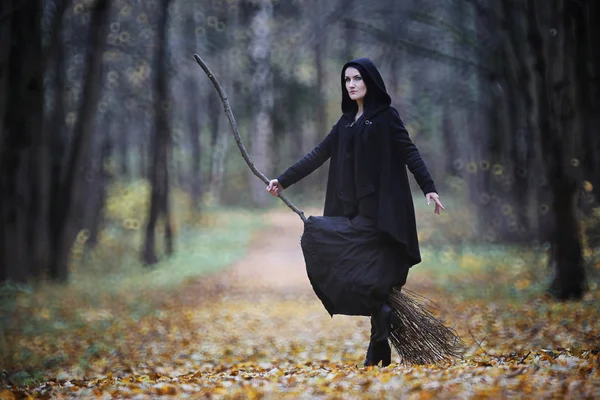 Une femme en costume de sorcière dans une forêt — Photo