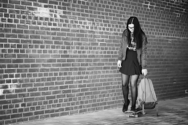 A young hipster girl is riding a skateboard. Girls girlfriends f — Stock Photo, Image