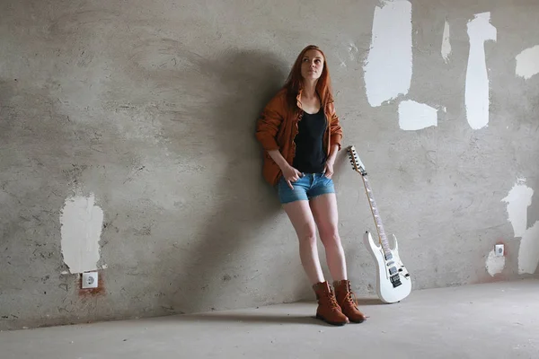 Fiatal vörös hajú lány egy elektromos gitár. Rock zenész lány — Stock Fotó