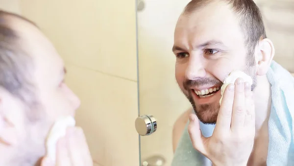 Um homem faz a barba na casa de banho pela manhã — Fotografia de Stock