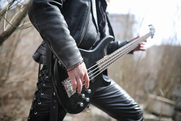 Guitarrista de rock nos degraus. Um músico com uma guitarra baixo em um — Fotografia de Stock