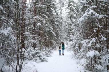 Genç bir aile yürüyüşe çıktı. Anne ve kızı şarapla yürüyorlar.
