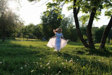Bir bahar parkta bir karahindiba çiçek tohumlarından üfleme teen