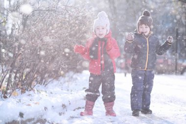 Çocuklar parkta ilk kar yürümek