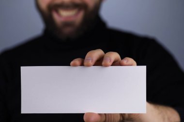 Elinde küçük beyaz bir kağıt parçası vardı.