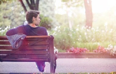 Genç bir adam öğle yemeği zamanında parkta yürür. Bir adam yürüyüşe çıktı. 