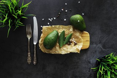 Avokado yemek tarifleri. Olgun yeşil avokado ahşap bir kesim üzerinde 