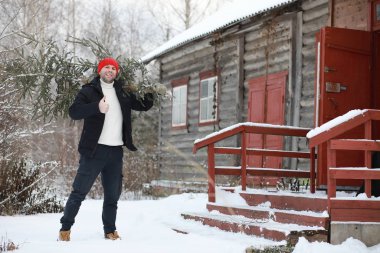 Sokakta kesilmiş bir Noel ağacı olan bir adam. N için Hazırlık