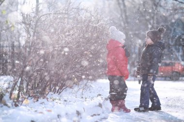 Çocuklar parkta ilk kar yürümek