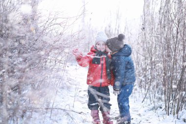 Çocuklar parkta ilk kar yürümek