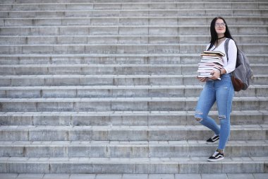 Kız öğrenci kitapları ile sokakta