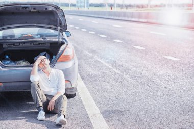 Yoldaki bir arabanın tekerleğini değiştirmek. Lastik işi yapan bir adam. 