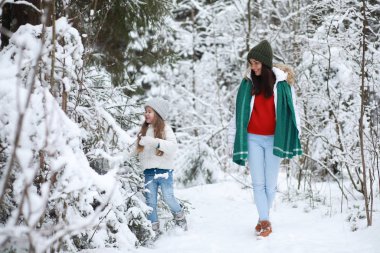 Genç bir aile yürüyüşe çıktı. Anne ve kızı şarapla yürüyorlar.