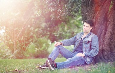 Genç bir adam öğle yemeği zamanında parkta yürür. Bir adam yürüyüşe çıktı. 