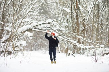 Kışın ormanda bir adam. Sırt çantalı bir turist.