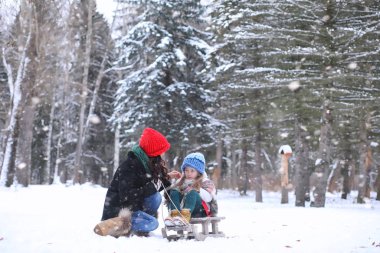 Bir kış masal, genç bir anne ve kızı bir kızak sürmek