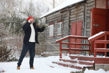 Sokakta kesilmiş bir Noel ağacı olan bir adam. N için Hazırlık