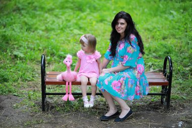 Parkta yürüyüş yapan tatlı kızıyla anne.