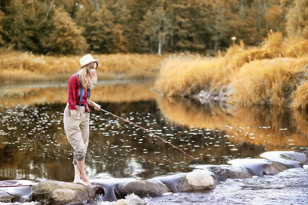 Chica en otoño con una caña de pescar — Foto de Stock