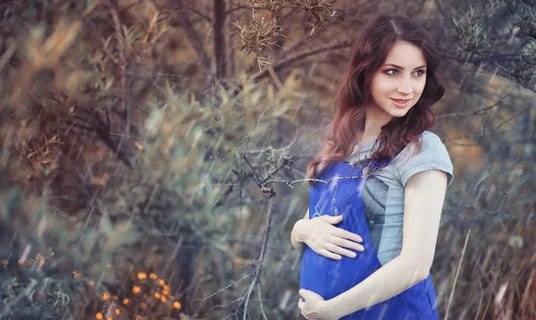 Mulher grávida em um passeio no parque — Fotografia de Stock