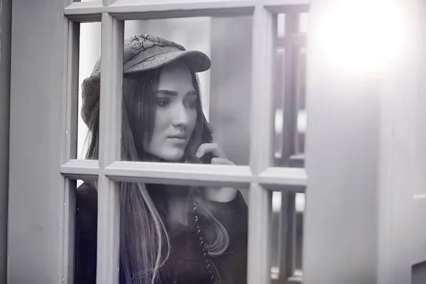 Beautiful young girl in a phone booth. The girl is talking on th — Stock Photo, Image