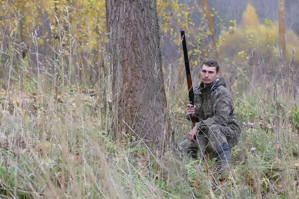 Hombre en camuflaje y con armas en un cinturón forestal en un hun de primavera —  Fotos de Stock