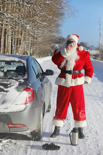 Santa Claus comes with gifts from the outside. Santa in a red su — Stock Photo, Image