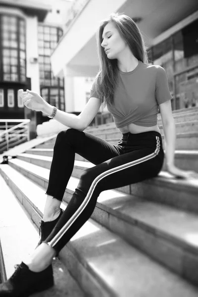 Una chica posando en los escalones de un edificio — Foto de Stock