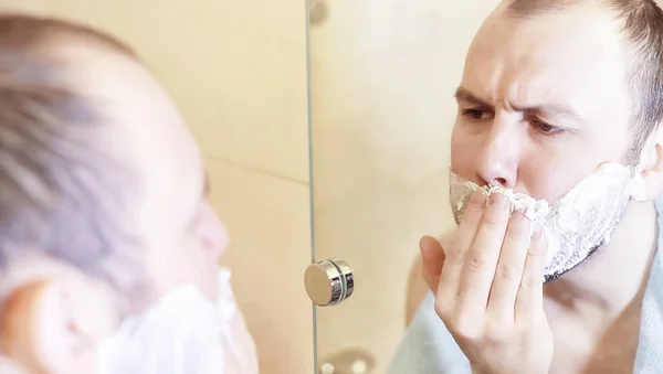 Muž se ráno holí v koupelně. — Stock fotografie