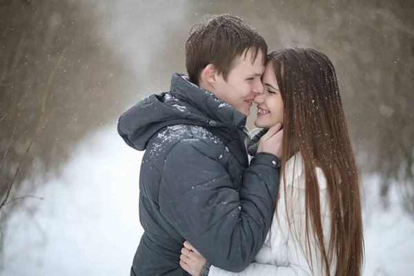 Pareja de amantes en una fecha tarde de invierno en una ventisca de nieve — Foto de Stock