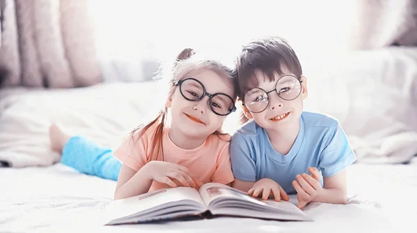 Kinder liegen auf dem Bett neben dem Neugeborenen, kleine Schwester. — Stockfoto