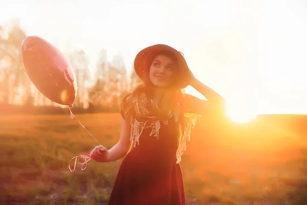 Una ragazza con un cappello mentre passeggia nel parco. Una ragazza con un cesto a piedi — Foto Stock