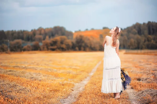 Flicka med en bukett blommor på hösten — Stockfoto