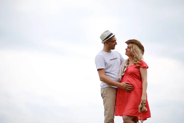 Fille enceinte avec gros ventre et jeune homme en plein air — Photo