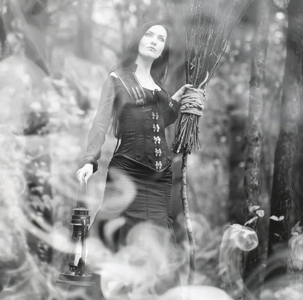 Mulher em um terno de bruxa em uma floresta densa — Fotografia de Stock