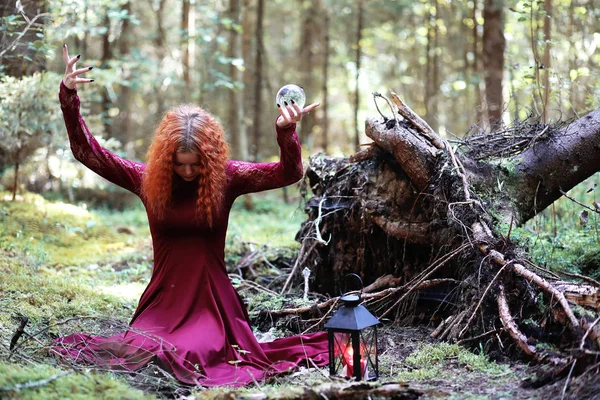 La bruja pelirroja sostiene un ritual con una bola de cristal — Foto de Stock