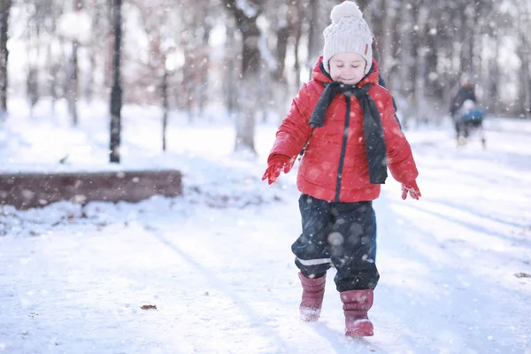 Los niños caminan en el parque primera nieve — Foto de Stock